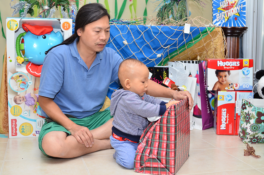 Daddy helps William to open the gifts
