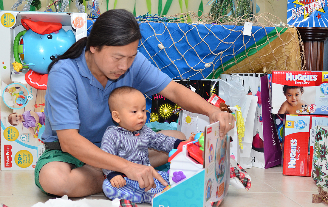 Daddy helps William to open the gifts
